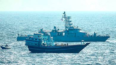 المدمرة الأمريكية (يو إس إس كول) مع سفينة التهريب المضبوطة