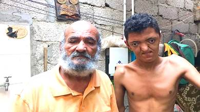 المواطن هشام محمد صالح مع ابنه المعاق